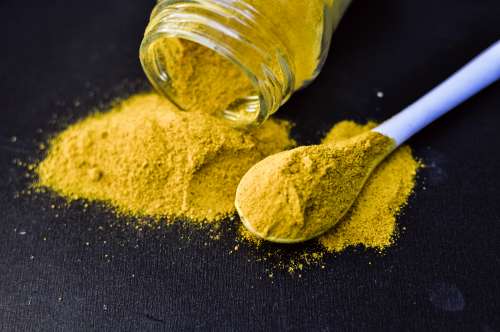 heap of yellow curcuma turmeric spices powder isolated on Black background free image