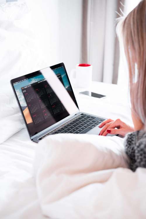 Young Woman Using Her Laptop in Bed
