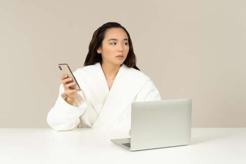 Young Asian Woman Using Phone And Doing Online Shopping