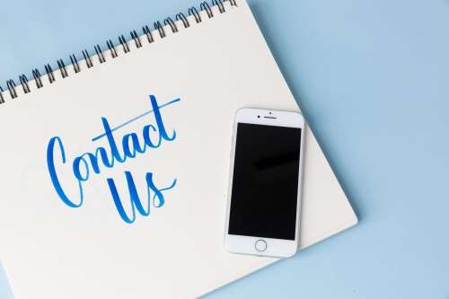 A Phone On A Blue Background With 'Contact Us' Photo