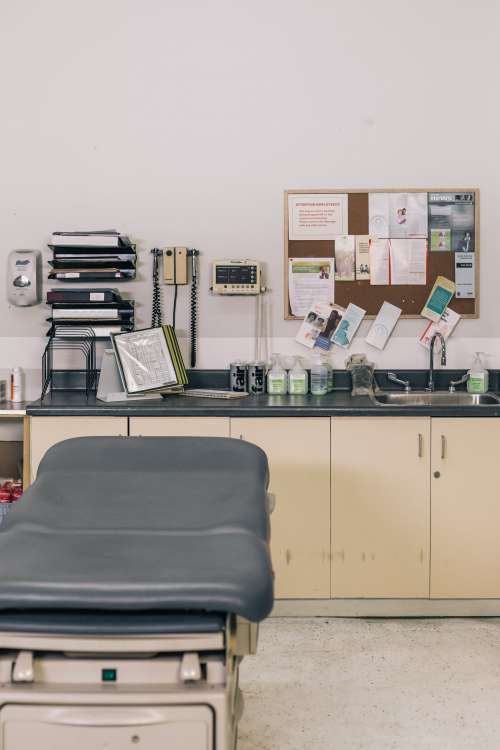 Empty Medical Examining Table Sitting Next To Supplies Photo