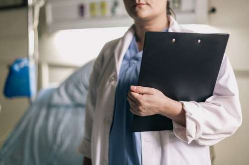 Female Medical Professional Holds Clipboard In Hospital Room Photo