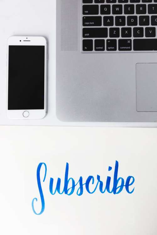Subscribe Written Under A Phone And Laptop Photo