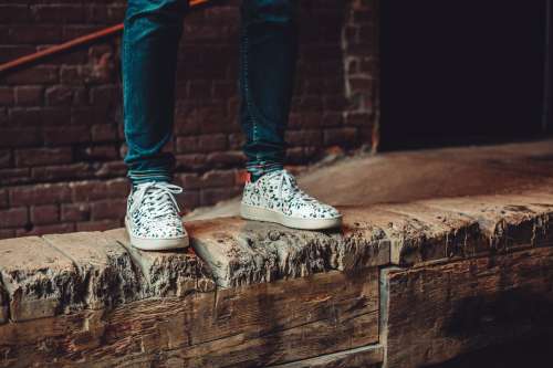 White Patterned Sneakers On Wooden Wall Photo