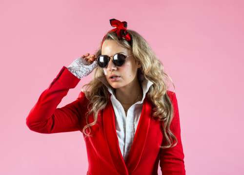 A Model In Red Suit Jacket Removing Sunglasses Photo