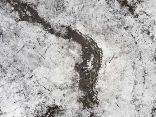 A Stream Flows Through The Snowy Landscape Photo
