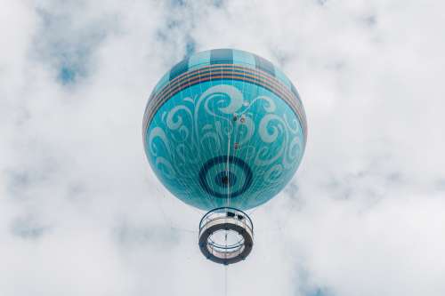 Aquamarine Hot Air Balloon Rises Into Puffy Clouds Photo
