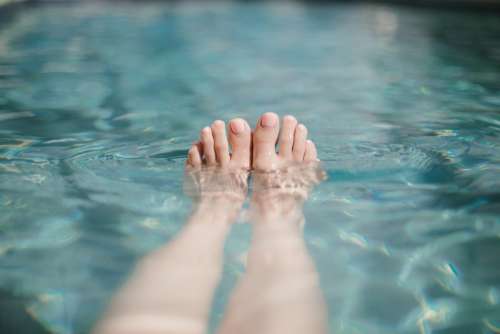 Baby Pink Painted Toes Peeking Out Of Swimming Pool Photo