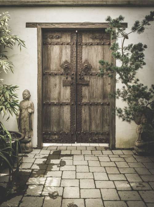 Carved Stone Buddhas Adorn Ornate Wooden Doorway Photo