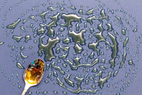 Golden Spoon And Metallic Liquid Photo