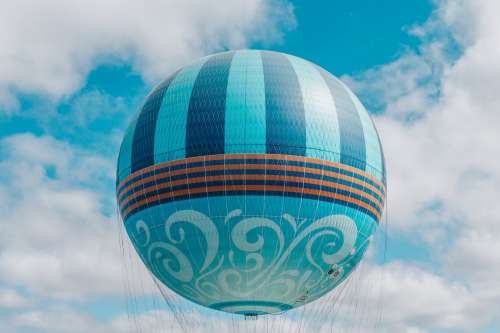 Playful Patterned Sphere Hot Air Balloon Floats In Blue Sky Photo