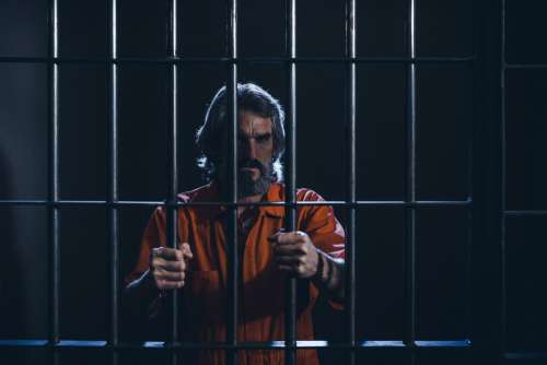 Prisoner Holds Cell Bars Tightly Photo