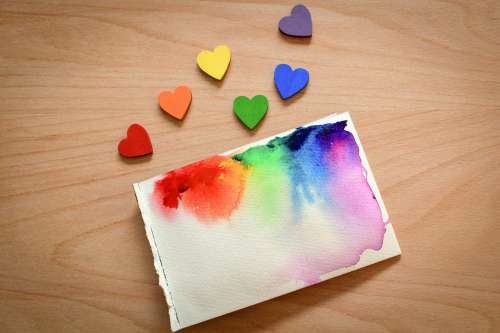 Rainbow Painted Wooden Hearts Beside Watercolour Canvas Photo
