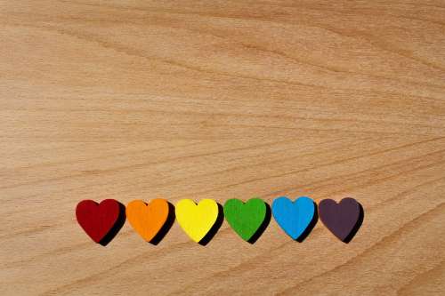 Rainbow Wooden Hearts Lined Up On Oak Table Photo