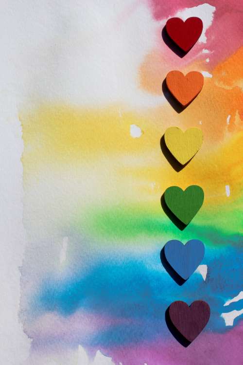 Rainbow Wooden Hearts Lined Up On Watercolour Canvas Photo