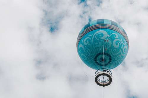 Teal Hot Air Balloon Floats Up Into White Puffy Clouds Photo