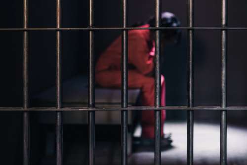 The Faint Shape Of A Prisoner Behind Black Prison Bars Photo