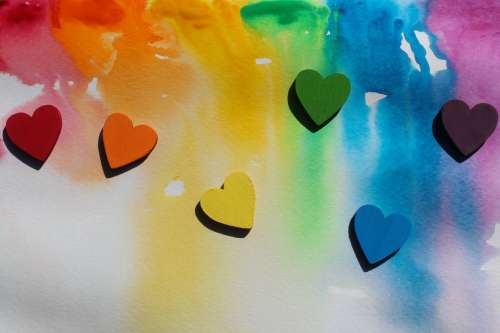 Tiny Wooden Rainbow Hearts On Watercolour Painted Background Photo