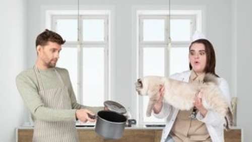 Surprised Young Woman Holding Cat And Man Holding An Empty Pan