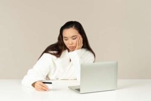 Bored Young Asian Woman Doing Online Shopping