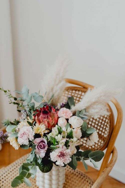 Beautiful bouquet of flowers on a wooden chair