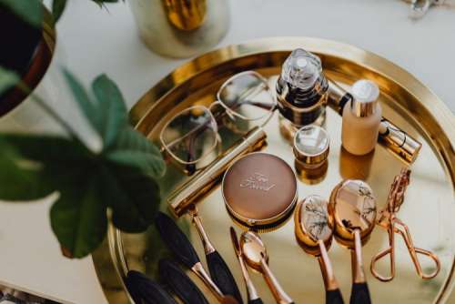 Makeup essentials on a golden tray