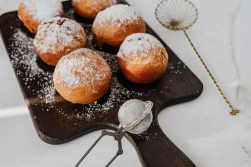 Homemade doughnuts covered with powdered sugar. Fat Thursday in Poland.