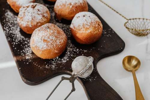 Homemade doughnuts covered with powdered sugar. Fat Thursday in Poland.
