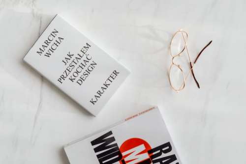 Book and glasses on white marble
