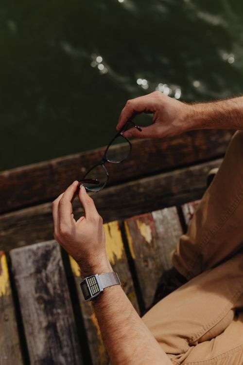 Closeup of glasses & vinatage watch on wrist of man