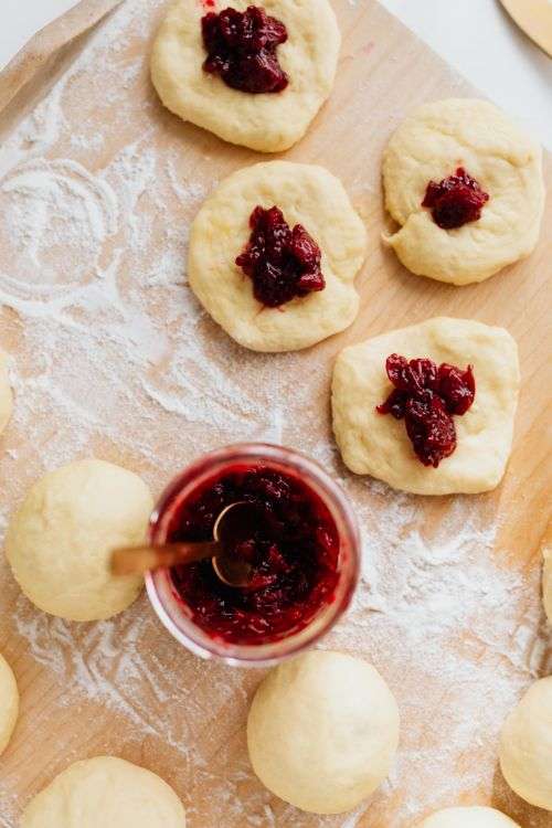 Adding cherry marmalade to Polish donuts - Paczki