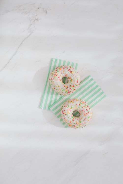 Donuts on paper napkins placed on white marble