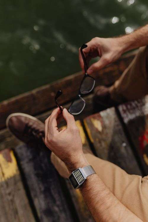 Closeup of glasses & vinatage watch on wrist of man