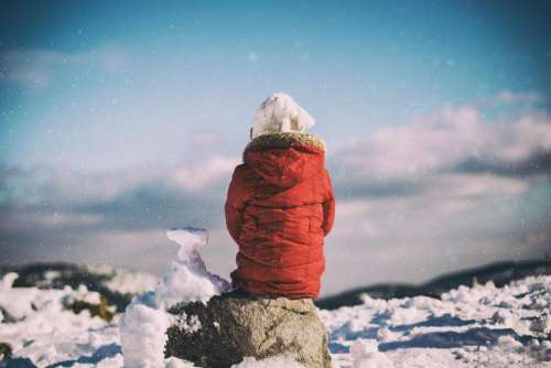 people sitting alone rocks snow