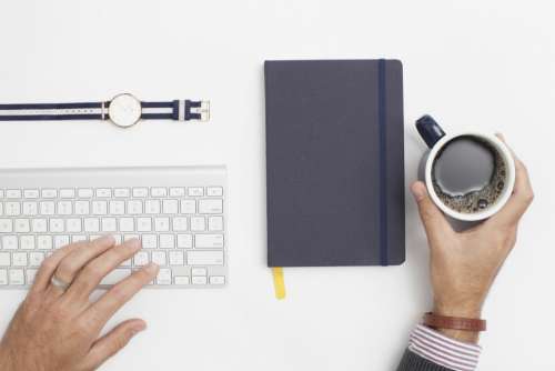 office desk hands keyboard cup