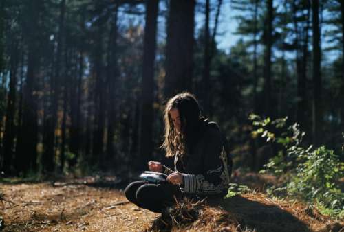girl reading forest trees long hair