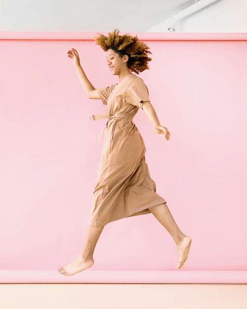 woman jumping pink background hair