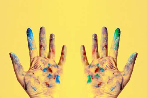 colorful paint hands yellow background