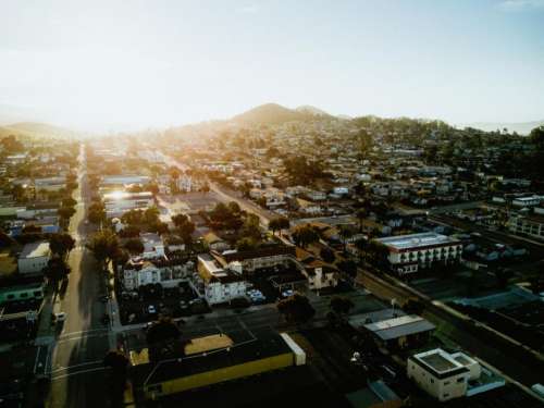 city buildings roads mountains sun