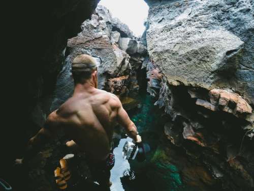 people man rocks water cave