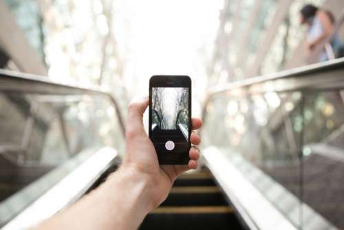 holding smartphone escalator stairs mobile