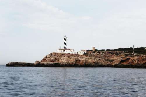 lighthouse coast sea rocks water