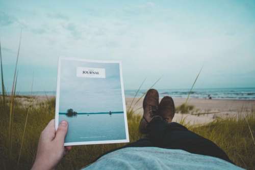 reading journal book lying down beach