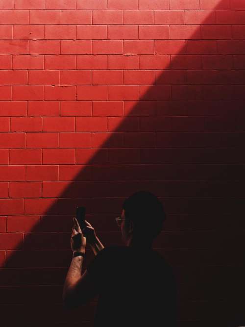 red wall sunlight dark people