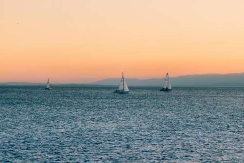 sunset sky sailboats lake water