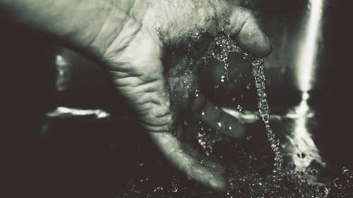 black and white hand fingers running water drop