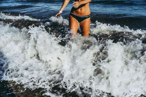 woman bikini splashing waves breaking