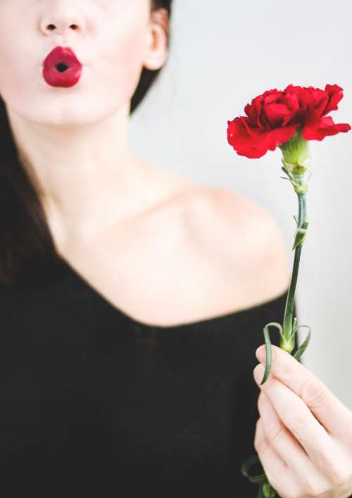 woman blowing kiss flower red female
