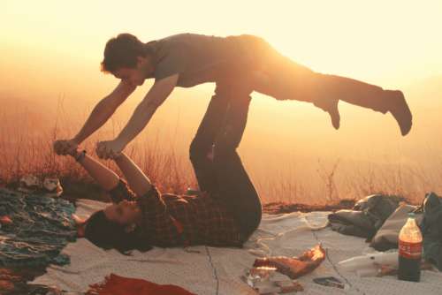 woman lifting man blanket picnic