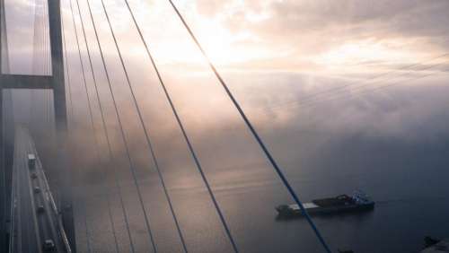 infrastructure bridge fog boat clouds